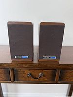 Front view of both Koss M60 Plus speakers with grille and badges visible