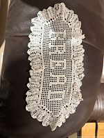 Crocheted oval doily reading BREAD