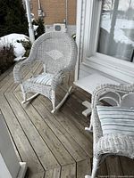 Both wicker rocking chairs and side table on deck