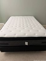 Front view of assembled queen mattress on box spring and metal frame