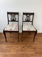 Front view of both chairs showing overall design, wood finish and patterned upholstery