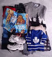 All items laid out; shows sweaters stack, Star Wars shorts, New Balance shoes, Maple Leafs jersey