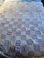 Entire quilt spread on bed showing checkerboard pattern and size