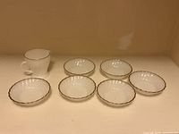 Creamer and six bowls lined up for full view