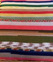 Full view of afghan showing multicolour horizontal stripes