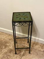 Full view of green metal pedestal table front angle