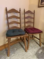 Pair of brown ladder-back chairs with cushions