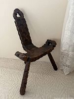 Full view of carved walnut tripod birthing chair showing backrest, seat, and three legs