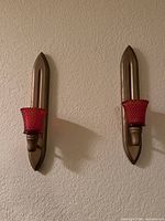pair of wooden wall sconces with red votives mounted on wall