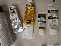 Group showing various paint tubes and a spray varnish can