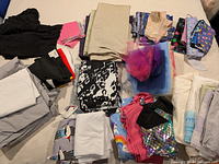 Overview of all folded fabric pieces laid out, showing variety of colours, prints, materials