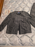 Front view of grey Mexx jacket laid flat on mattress