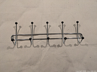 full view of chrome coat rack showing 10 hooks and mounting holes