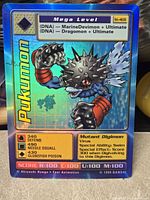 Front of holographic Pukumon card showing character art, stats and Bandai copyright