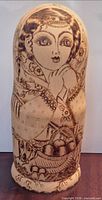 Front view of largest nesting doll showing pyrography artwork
