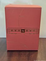 Front of red retail box featuring Nespresso train graphic