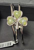 Close-up of bangle showing shamrock motif and tag