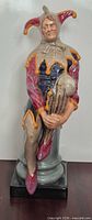 Front view of Royal Doulton The Jester figurine on pedestal base