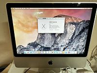 Front view of iMac powered on showing OS X Yosemite desktop