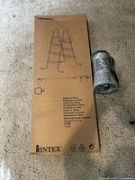 Boxed Intex ladder and wrapped pump