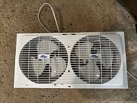 Top view of Cool Works twin window fan showing two 9-inch blades and cord