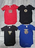 Group shot of four bodysuits on hangers