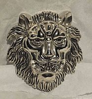 Front view of silver-tone lion head belt buckle