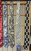 Five ties with skull and swirl designs shown hanging