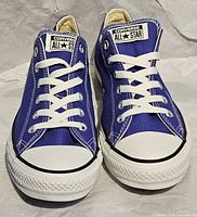Front view of both shoes showing blue canvas uppers, white toe caps, laces, and tongue labels