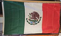 Full view of Mexico flag showing tricolor stripes and coat of arms