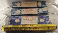 Three blue Nag Champa boxes and one yellow Sandesh Lemon box stacked