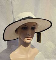Front view of white hat on mannequin showing black edge and tag