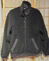 Front view of black fleece jacket showing pockets, zipper and collar