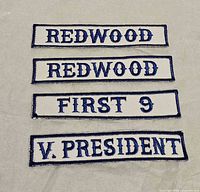 Four rectangular embroidered patches laid flat showing text variants