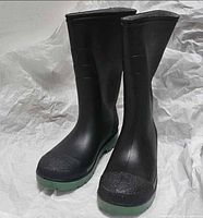 Side view of both black and green rain boots