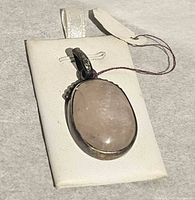 Front view of oval rose quartz pendant in sterling silver setting