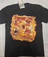 Front of black T-shirt laid flat showing full Judas Priest flame graphic