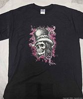 Full view of front of black t-shirt showing skull with top hat graphic and Gildan neck tag