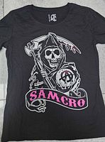 Front view of folded black SAMCRO T-shirt showing full graphic