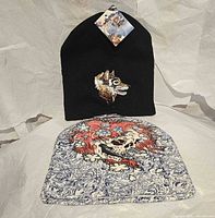 Front view of both beanies showing wolf embroidery and skull graphic