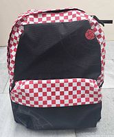 Front view of Vans x Marvel Spider-Man backpack showing checkerboard trim and web graphic