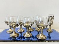 Full set of glassware on blue tray showing silver holders