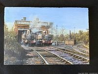 Front view of oil painting showing two steam locomotives outside shed, signature visible