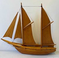 Full starboard side of carved pine sailboat showing hull, masts, sails
