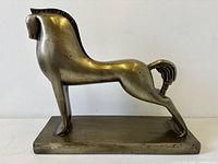 Right side view of metallic horse sculpture on rectangular base