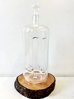 Front view of glass ship in bottle on wood base
