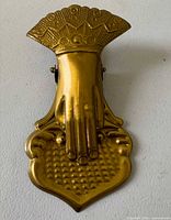 Front view of bronze-finish hand-shaped clip