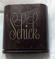 Front of dark brown leather case with gold Schick script