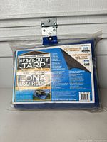 Front of packaged heavy-duty tarp showing size, reversible feature