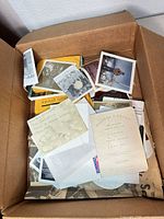 Open box showing loose vintage prints in assorted sizes and colors